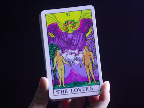 Person reading tarot cards laid out on a table